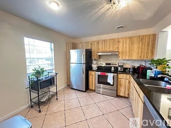 A kitchen with wooden cabinets and a stainless steel refrigerator.