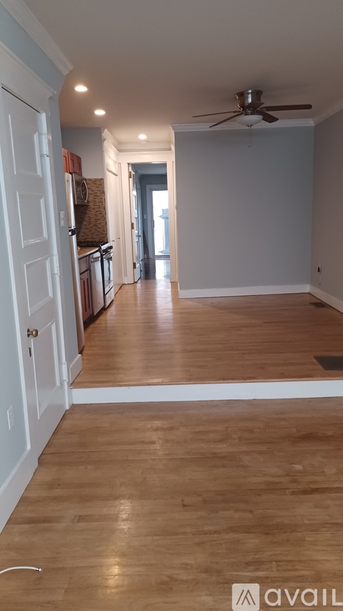 A room with wooden flooring and a ceiling fan.
