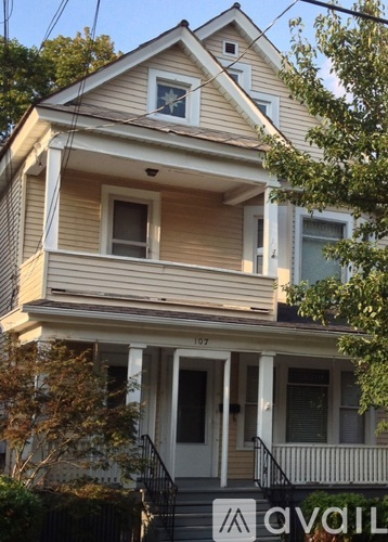 A two-story house with a balcony and a small front porch.
