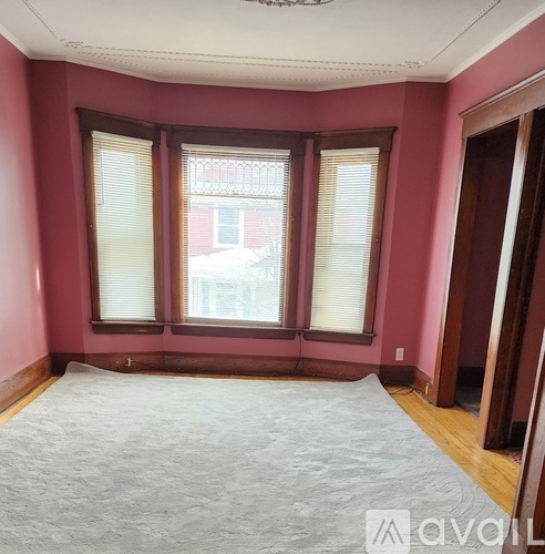 A room with a large window and a carpeted floor.