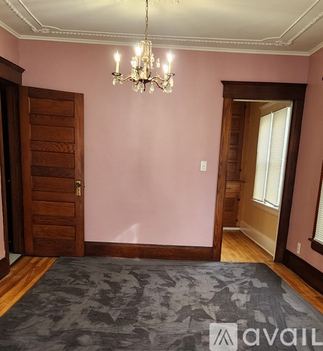 A room with a chandelier, a door, and a window.
