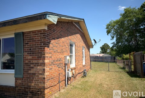 A brick house with a window and a fence in front.