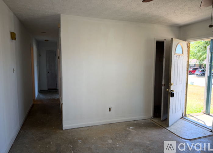 A room with a door on the right and a hallway on the left.