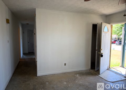 A room with a door on the right and a hallway on the left.