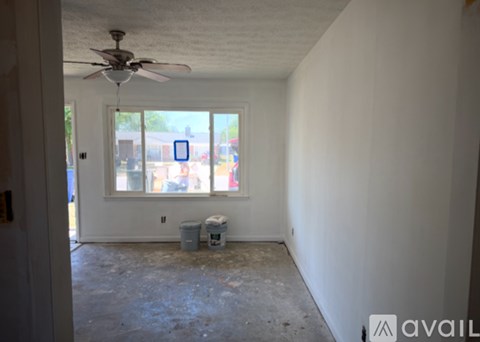 A room with a ceiling fan and a window showing an outdoor scene.