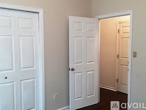 Two white doors in a room with one open.