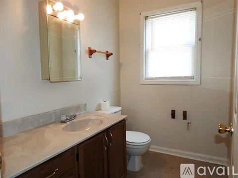 A bathroom with a sink, toilet, and a mirror.