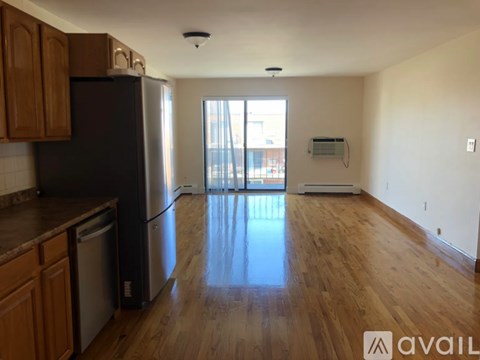 A kitchen with wooden cabinets and a black refrigerator.
