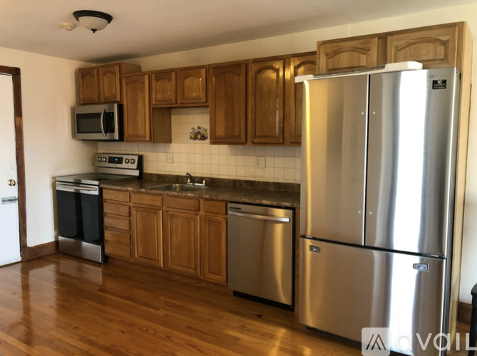 A kitchen with wooden cabinets and stainless steel appliances.