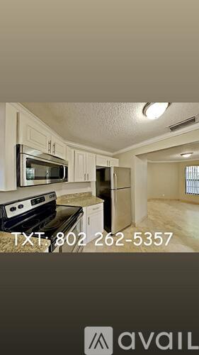 A kitchen with a stove, microwave, and refrigerator is shown with a phone number.