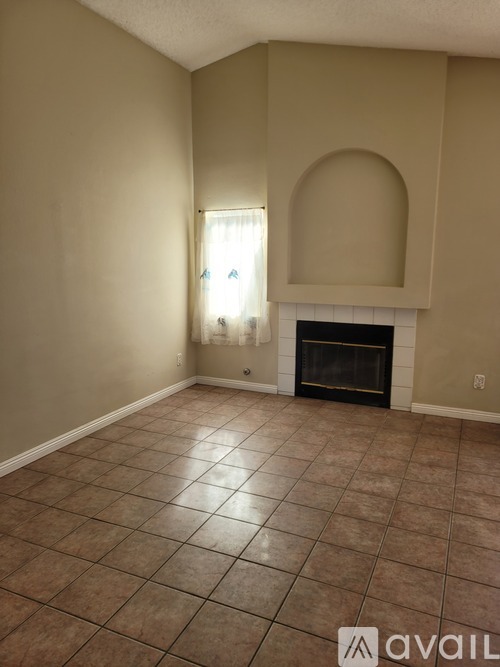 A living room with a fireplace and a window.
