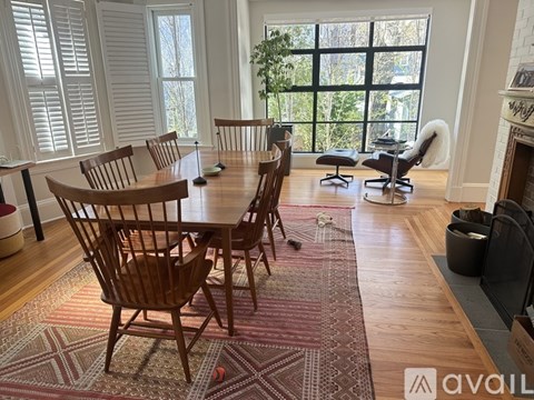A living room with a fireplace and a rug with a pattern.