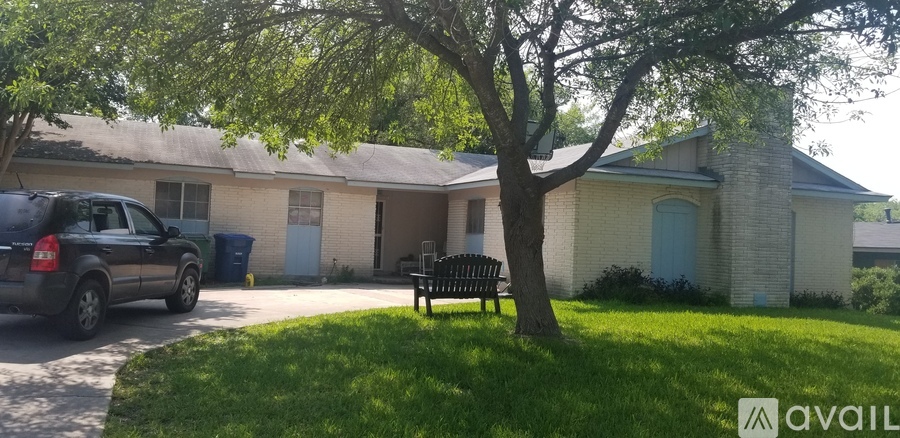 A house with a tree in front and a car parked in front of it.