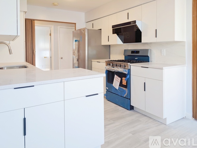 A kitchen with white cabinets and a blue stove top oven.