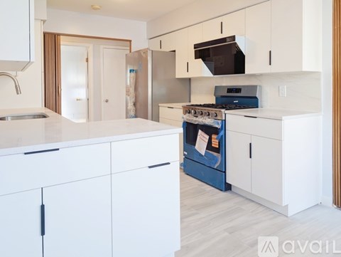 A kitchen with white cabinets and a blue stove top oven.