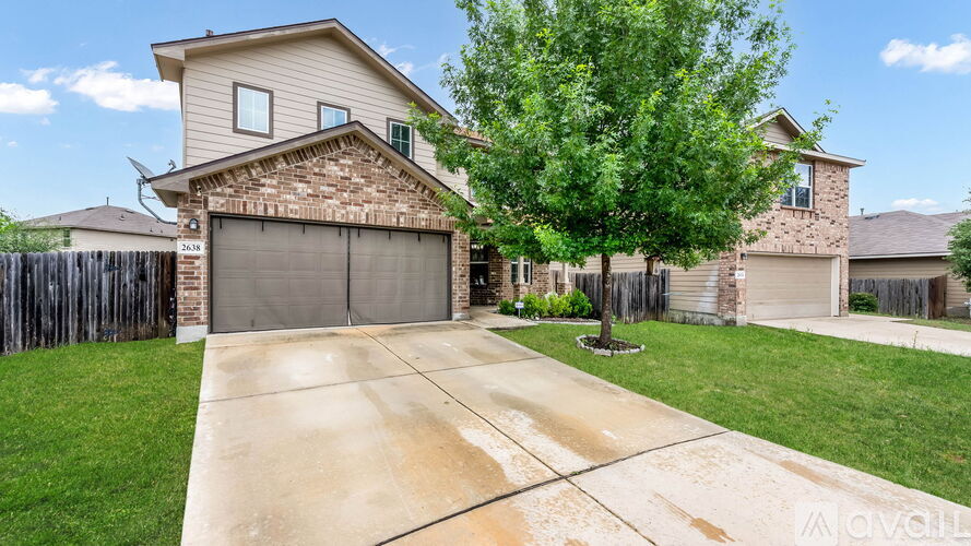 A house with a garage and a driveway in front.