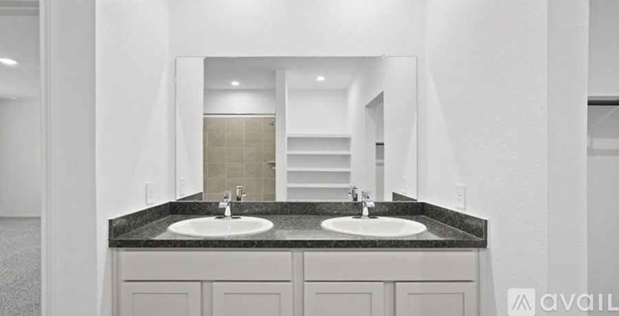 A bathroom with two sinks and a large mirror.