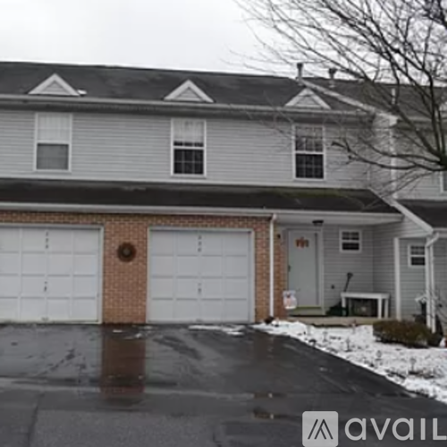 A house with a grey siding and a white garage door.