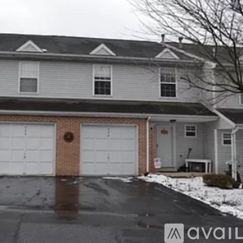 A house with a grey siding and a white garage door.