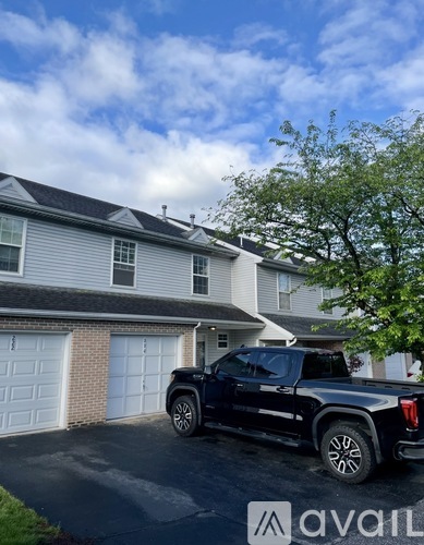 A black pickup truck is parked in front of a house with a white garage door.