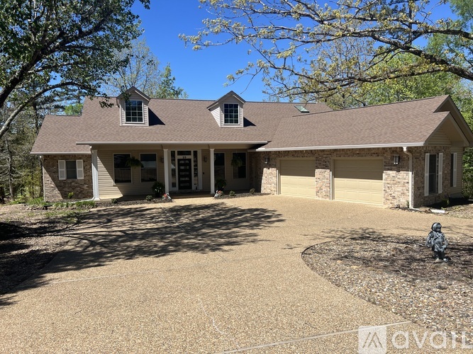 A house with a brown roof and a driveway in front of it.