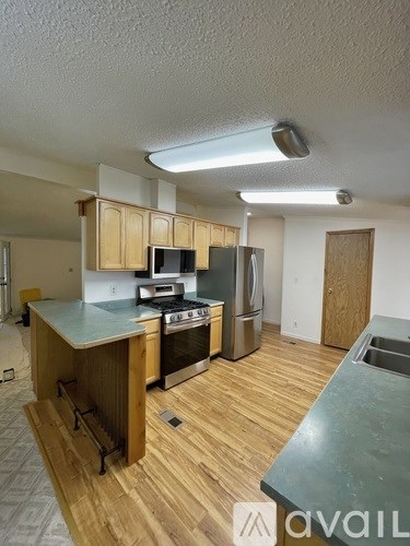 A kitchen with wooden cabinets and a stove top oven.