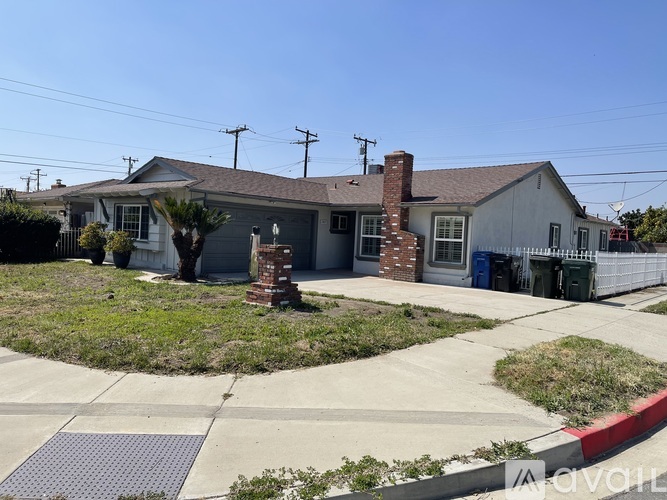 A house with a grey roof and a white fence.