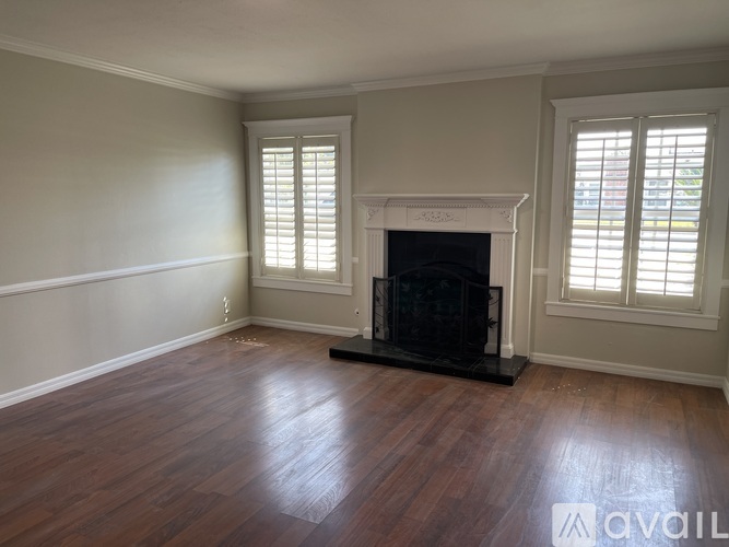 A living room with a fireplace and wood flooring.