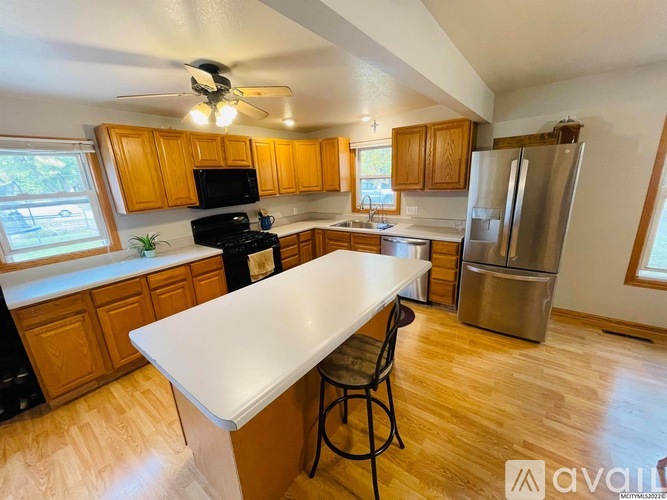 A kitchen with wooden cabinets and a white island.