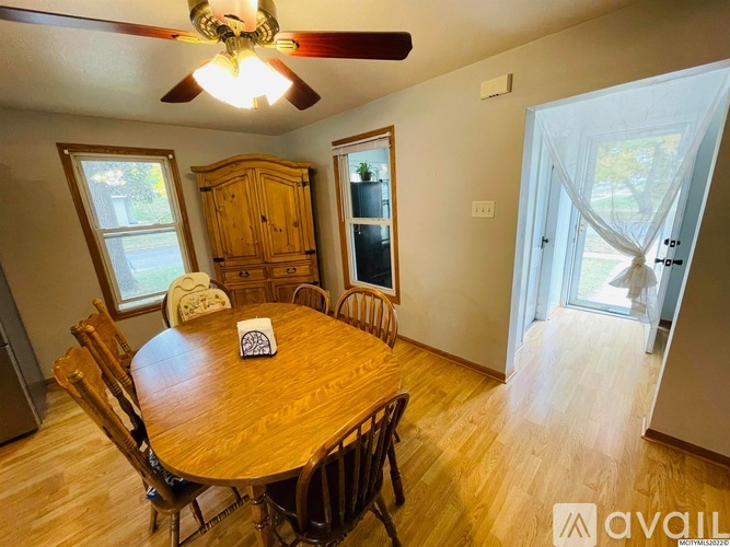 A dining room with a wooden table and chairs.