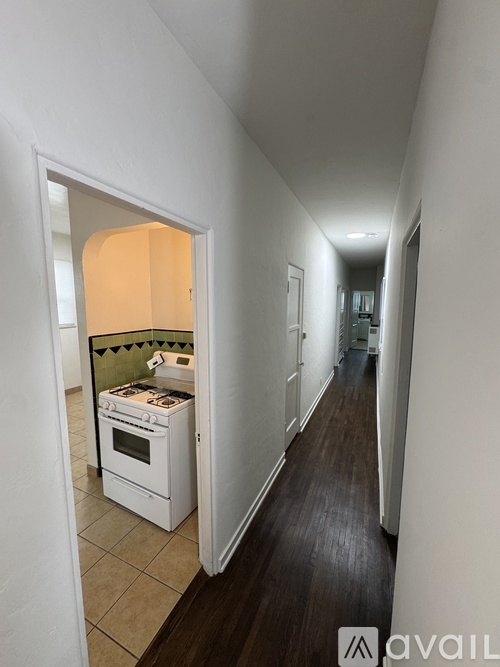A white kitchen with a stove and a white oven.