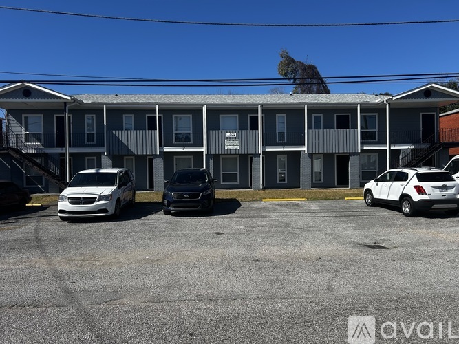 A parking lot with cars and a building in the background.