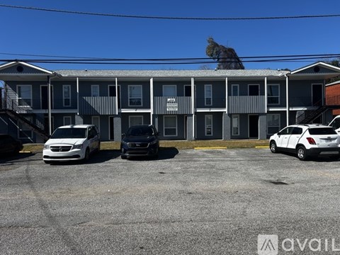 A parking lot with cars and a building in the background.