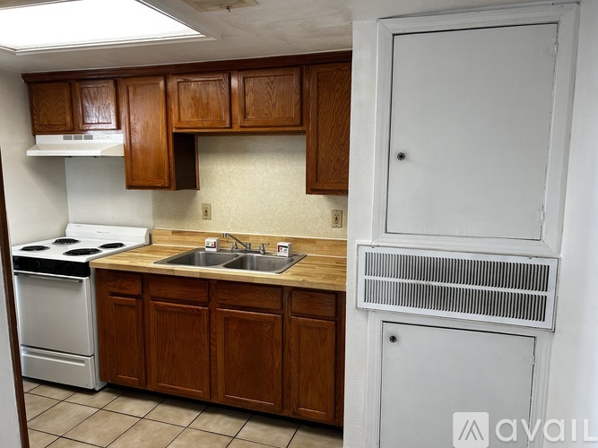 A kitchen with brown cabinets and a white stove.