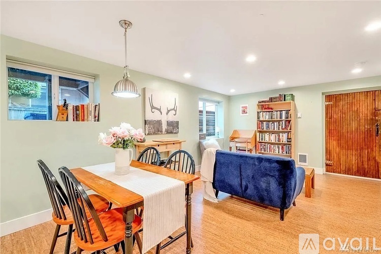 A dining room with a table set for four and a blue couch.