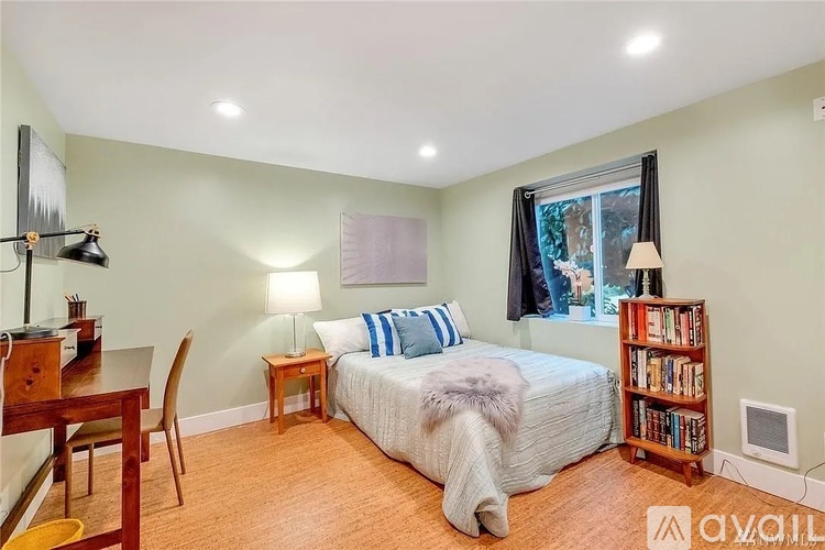 A bedroom with a bed, a desk, a chair, a lamp, and a bookshelf.