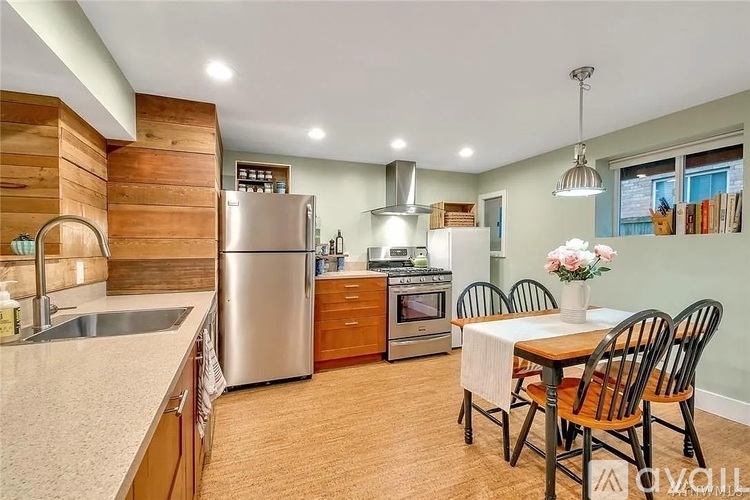 A kitchen with a table and chairs in front of it.