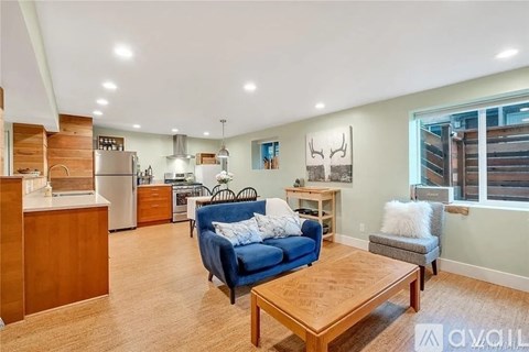 A living room with a blue couch and a wooden coffee table.