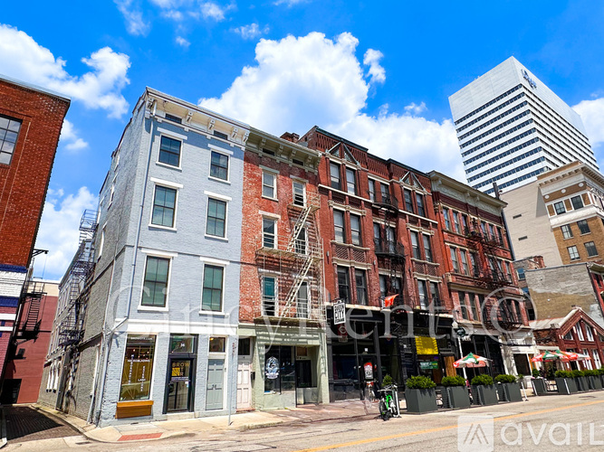 A row of buildings with a blue sky and clouds in the background.