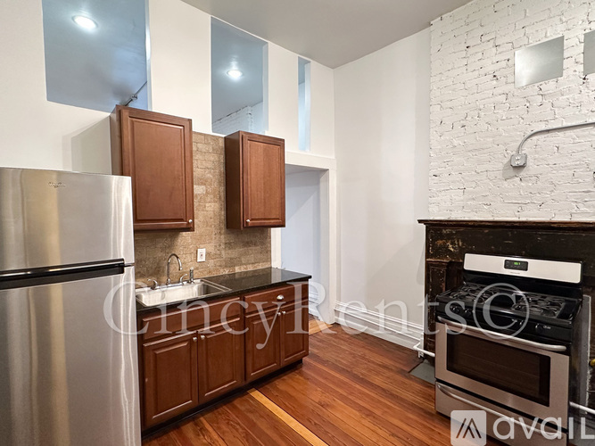 A kitchen with wooden cabinets and a stainless steel refrigerator.