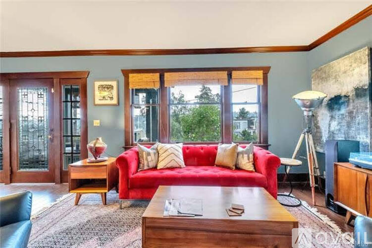 A living room with a red couch and a wooden coffee table.