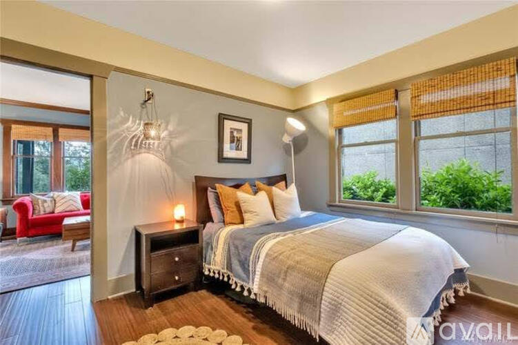 A bedroom with a large bed and a red chair.