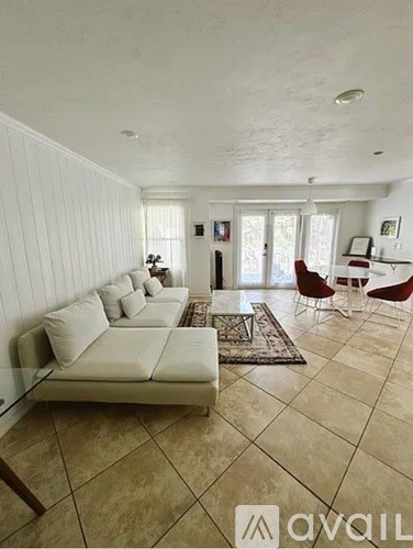 A living room with a white couch and a rug.