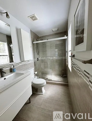 A bathroom with a toilet, sink, and shower.