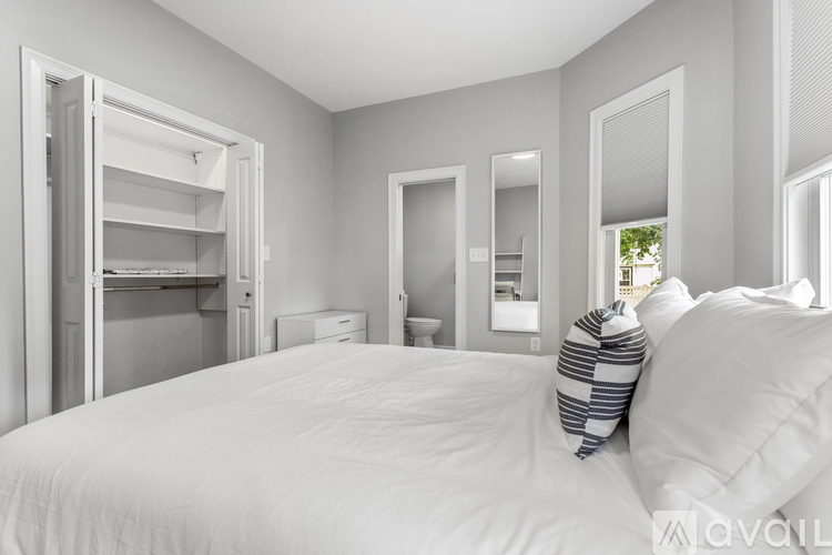 A bedroom with a large bed and a walk-in closet.