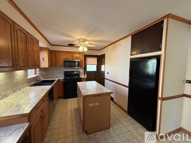 A kitchen with wooden cabinets and black appliances.
