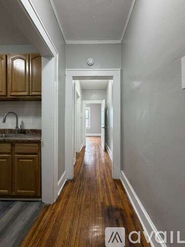 A long hallway with wooden floors and white walls.