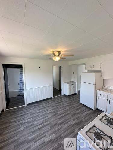 A kitchen with a grey floor and white walls.