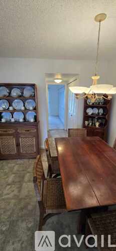 A dining room with a wooden table and chairs.