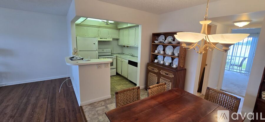 A kitchen with a dining table and chairs in the foreground and a kitchen island in the background.